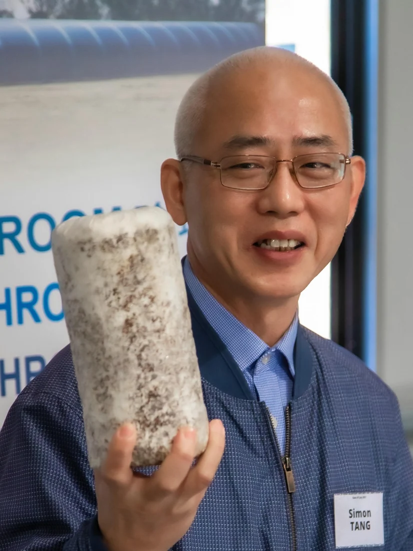A person displaying one of the company’s cylindrical mushroom substrate blocks
